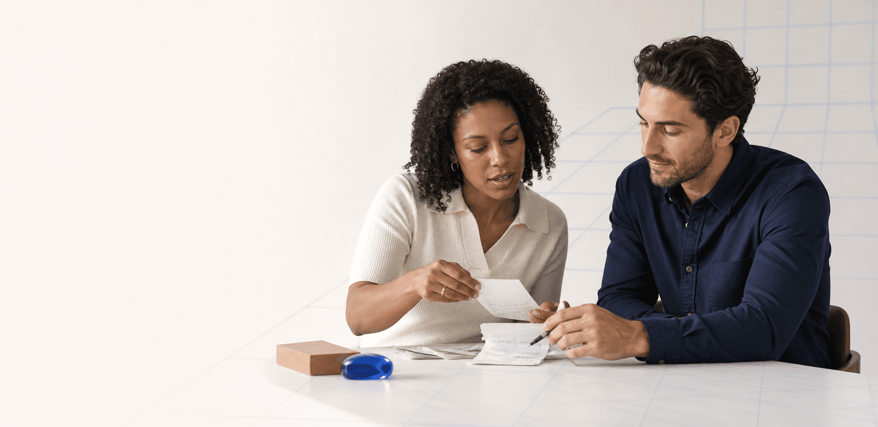 Two finance professionals reviewing a batch of source documents together