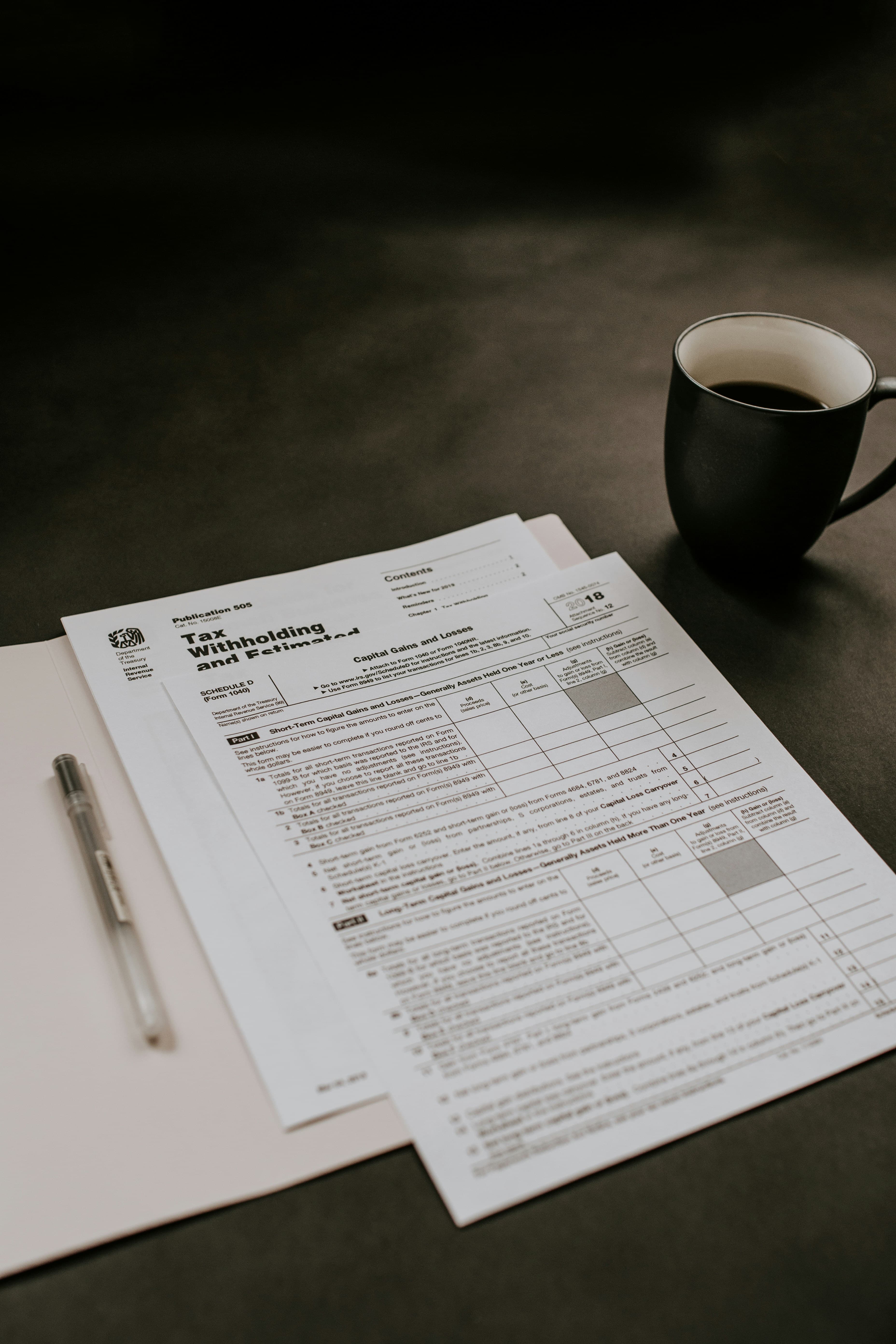 Statements and forms laid out beside a coffee
